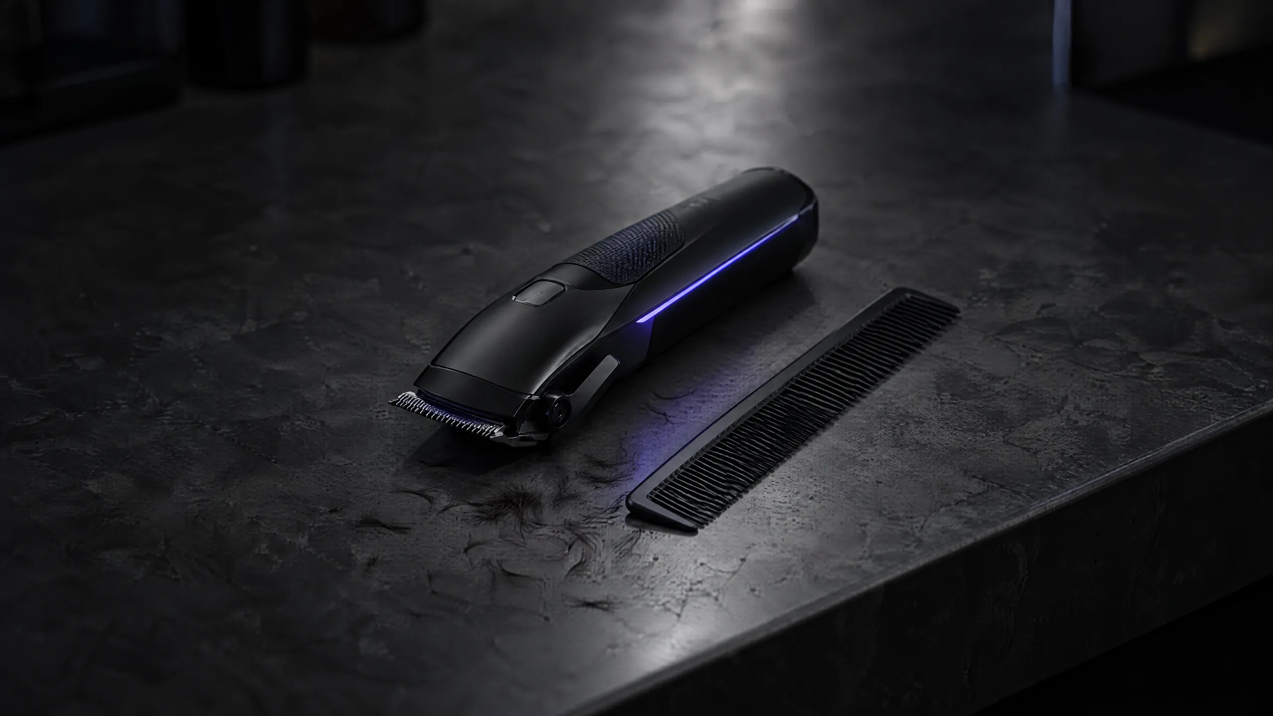 A black hair clipper and comb on a dark concrete counter